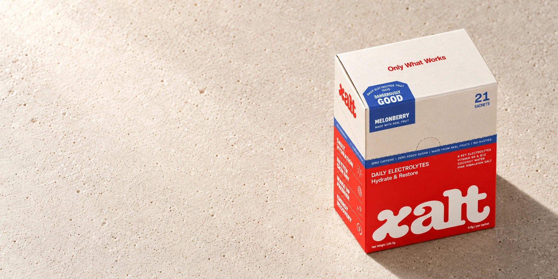 A box of XALT Melonberry on a sunlit stone floor
